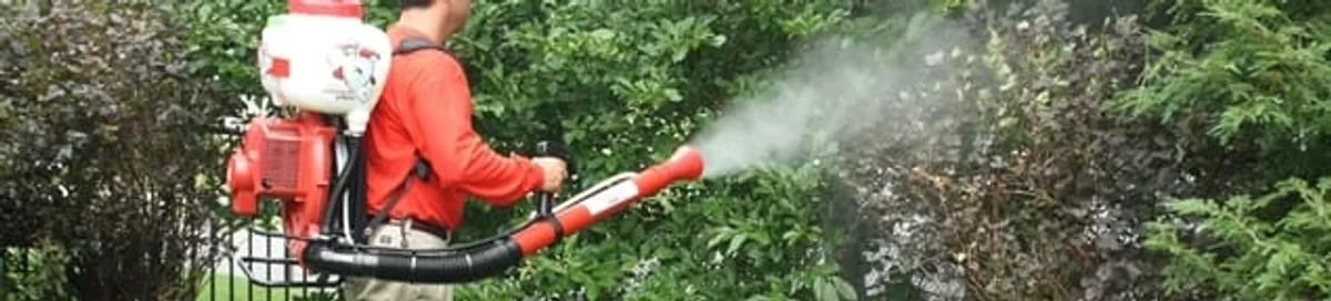 Mosquito control technician fogging shrubs and landscaping for mosquito treatment in Charleston, SC