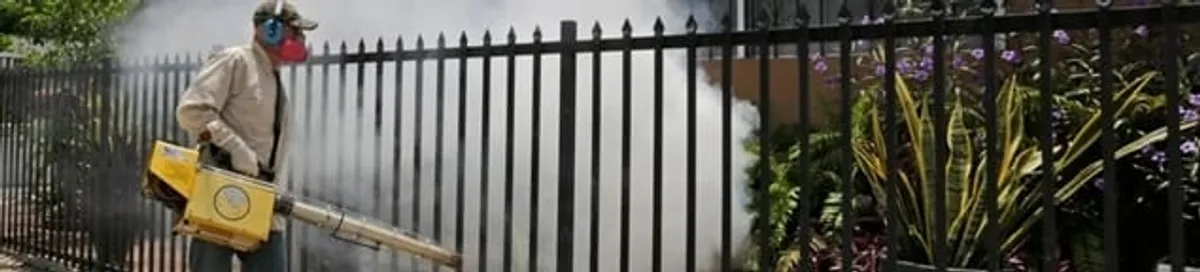 Mosquito control technician fogging a yard perimeter for mosquito reduction in Charleston, SC